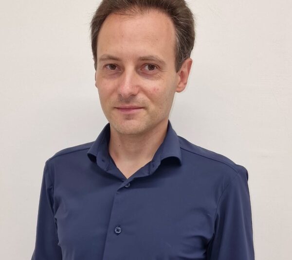 Uomo in camicia blu navy con bottoni, sorriso professionale, sfondo bianco - membro Rotarian Gourmets WFRG