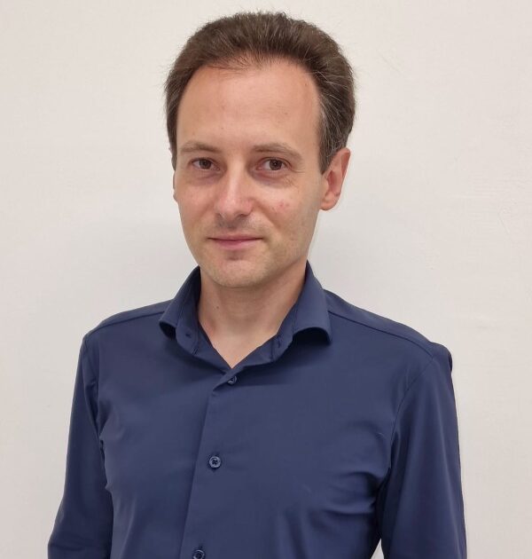 Uomo in camicia blu navy con bottoni, sorriso professionale, sfondo bianco - membro Rotarian Gourmets WFRG