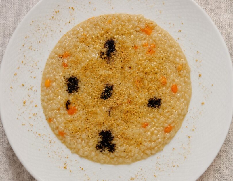 Risotto Acquerello con crema di cipolla paglierina Risotto Acquerello con crema di cipolla paglierina, riduzione di Merlot, zeste d’arancia e granella di pistacchio