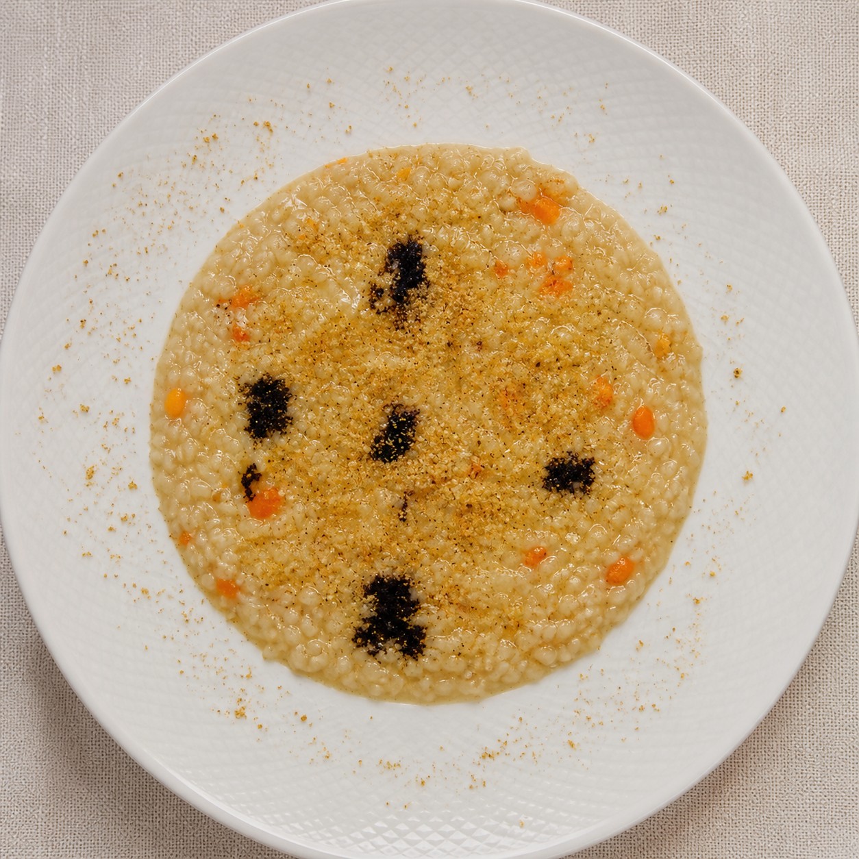 Risotto Acquerello con crema di cipolla paglierina Risotto Acquerello con crema di cipolla paglierina, riduzione di Merlot, zeste d’arancia e granella di pistacchio
